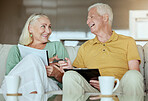 Happy elderly couple checking their finance and planning retirement. Senior caucasian man and woman smiling while planning and doing paperwork at home