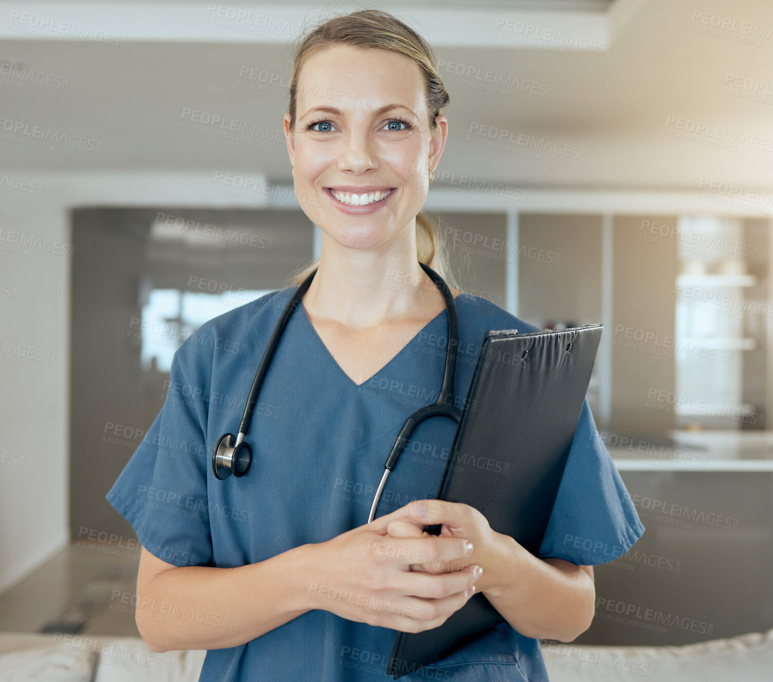 Buy stock photo A beautiful young doctor looking happy and friendly while waiting at work. Smiling caucasian health care worker wearing a stethoscope and holding a folder