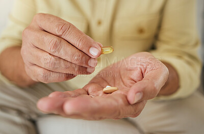 Buy stock photo An unknown man showing his pills while sitting at home. Unrecognizable mature man taking his daily treatment for chronic disease and illness