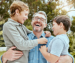 A happy caucasian single parent enjoying playing with his sons in the backyard. Smiling family of three males only having fun in a garden outside