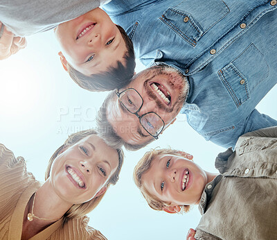 Buy stock photo Closeup of a family of four looking down and smiling. Caucasian couple sharing a huddle with their sons while playing in a garden or backyard