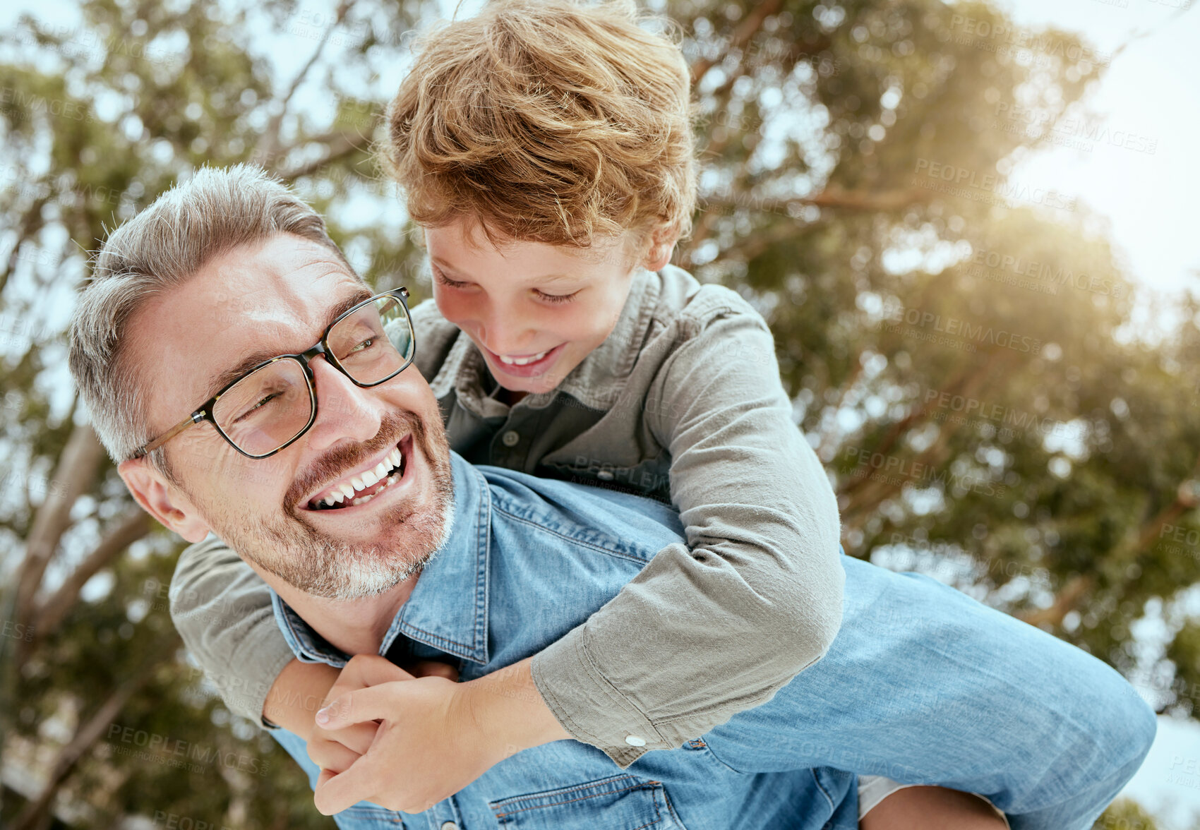 Buy stock photo Piggyback, fun and father with child in a park happy, playing and having fun in nature. Hug, love and parent carrying son in a garden, laughing and enjoying games, smile and together on the weekend