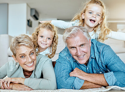 Buy stock photo Portrait of two little girls spending time with their grandparents on the lounge floor at home . Mature caucasian couple having fun with their grandchildren