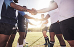 Two opponent rugby teams shaking hands before or after a match outside on a field. Rugby players sharing a handshake to show respect and sportsmanship. A mutual understanding for the game to be played