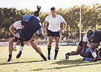 Caucasian rugby player attempting to tackle an opponent during a rugby match outside on the field. Young athletic man tackling an opponent in an attempt to stop him from scoring. Last line of defense