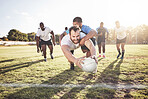 Caucasian rugby player diving to score a try during a rugby match outside on a field. Young male athlete making a dive to try and win the game for his team. Young man reaching out for the try line