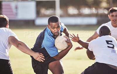 Buy stock photo African american rugby player running away from an opponent while attempting to score a try during a rugby match outside on a field. Black man making a play to try and win the game for his team