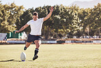 One caucasian rugby player kicking off during a rugby match outside on the field. Young athletic man taking a penalty or attempting to score a conversion during a game. He's the kicker on the team