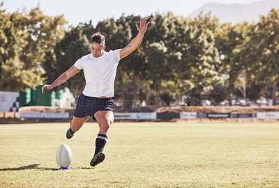 Buy stock photo One caucasian rugby player kicking off during a rugby match outside on the field. Young athletic man taking a penalty or attempting to score a conversion during a game. He's the kicker on the team