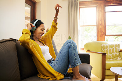 Buy stock photo Woman, music and relax with headphones dancing on living room sofa enjoying good vibes at home. Happy female with smile and dance listening to joyful audio streaming, relaxing on a couch at the house