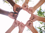 Closeup of fists in a circle outside in nature. Diverse group of peoples fists touching. Multiethnic people with their fists together