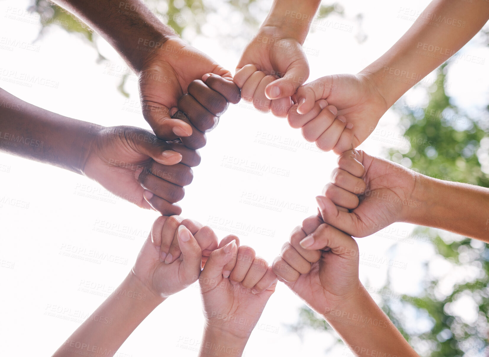 Buy stock photo Closeup of fists in a circle outside in nature. Diverse group of peoples fists touching. Multiethnic people with their fists together