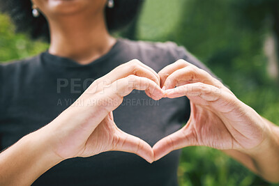 Buy stock photo Closeup of a person showing a heart gesture outside in nature. A female expressing love, care and peace using heart shaped gesture. A person showing the heart with their hands