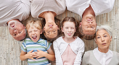 Buy stock photo A family bonding together and being playful, showing different expressions while bonding and enjoying quality time. Above happy fun family making silly faces lying together on a living floor at home.