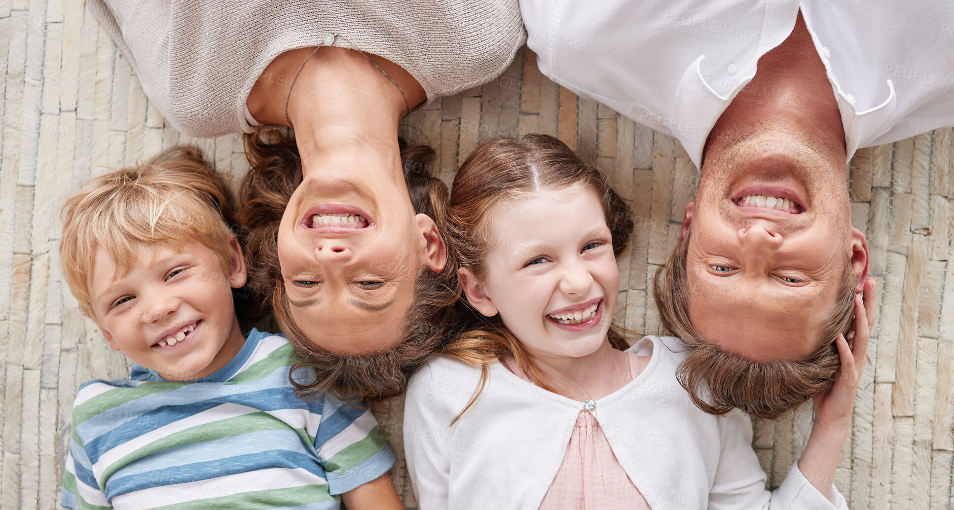 Buy stock photo Carefree loving parents from above relaxing with their cute little laughing son and daughter. Happy caucasian family of four relaxing and playing together. Cheerful kids spending time together