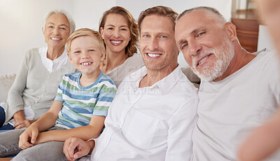 Portrait of happy generational caucasian family taking selfies at home. Little boy relaxing and bonding with carefree parents and grandparents while capturing photos and pictures for special memories