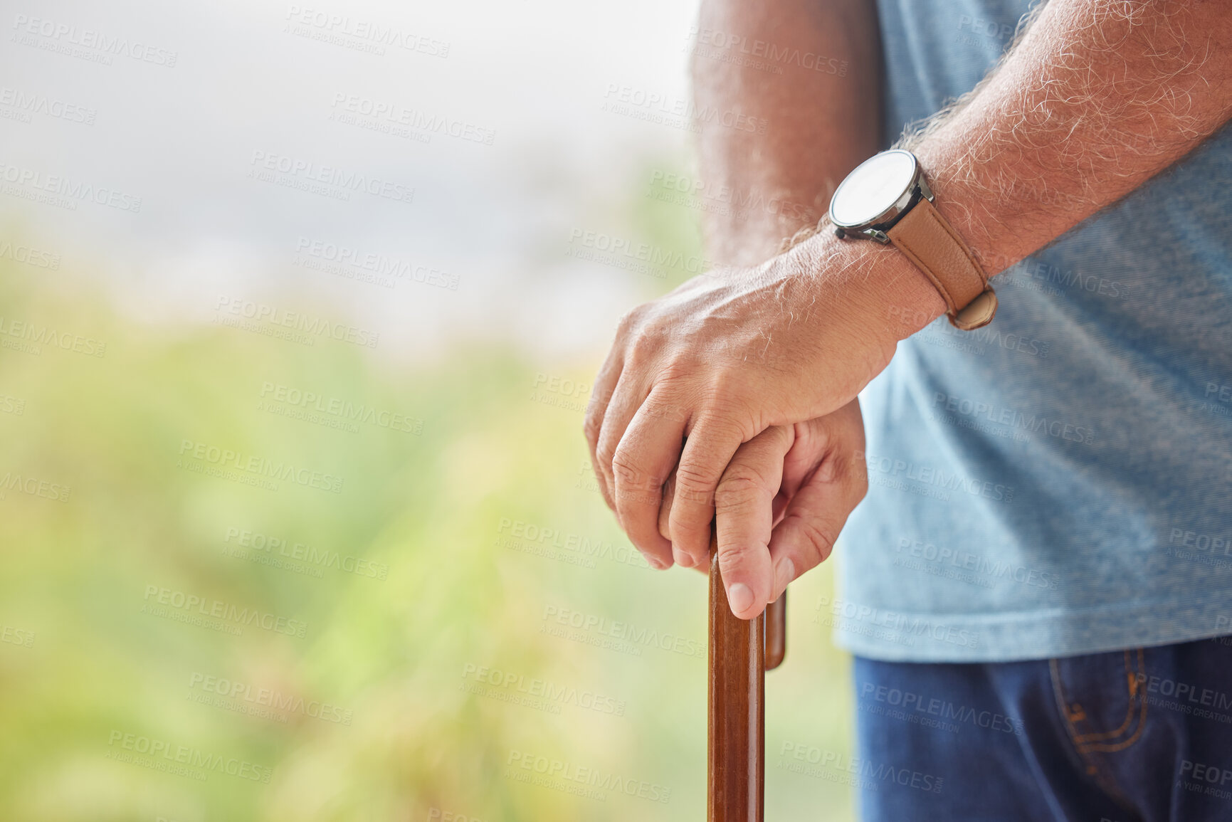 Buy stock photo Senior disabled man hands holding a cane outside in a nursing home park. Closeup of elderly male holding a walking aid outdoors, relaxing at a healthcare facility on the sunny day