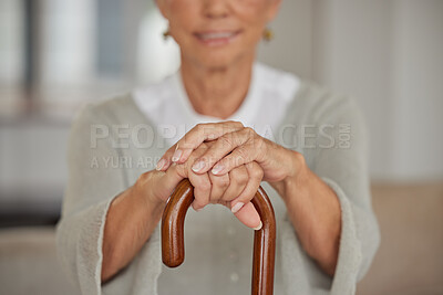 Buy stock photo Senior disabled woman holding a cane inside in a nursing home. Closeup of elderly lady holding a walking aid, relaxing at a healthcare facility while using a crutch for support at assisted living home