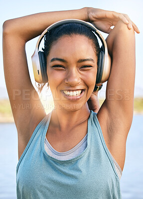 Buy stock photo Portrait of happy woman doing warmup stretches, using headphones for music and exercising outside. Smiling female athlete preparing body and muscle for training or  running cardio workout
