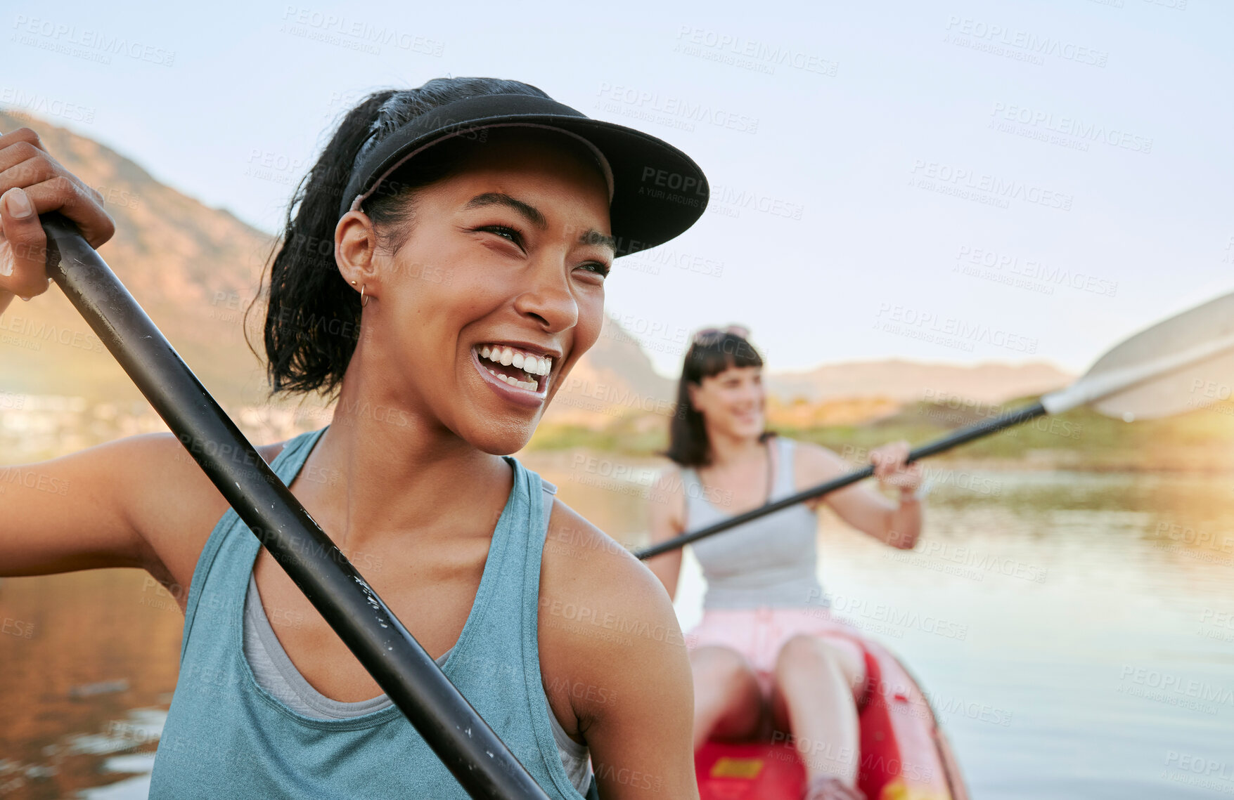 Buy stock photo Two smiling friends kayaking on a lake together during summer break. Smiling and happy playful women bonding outside in nature with water activity. Having fun on a kayak during weekend recreation