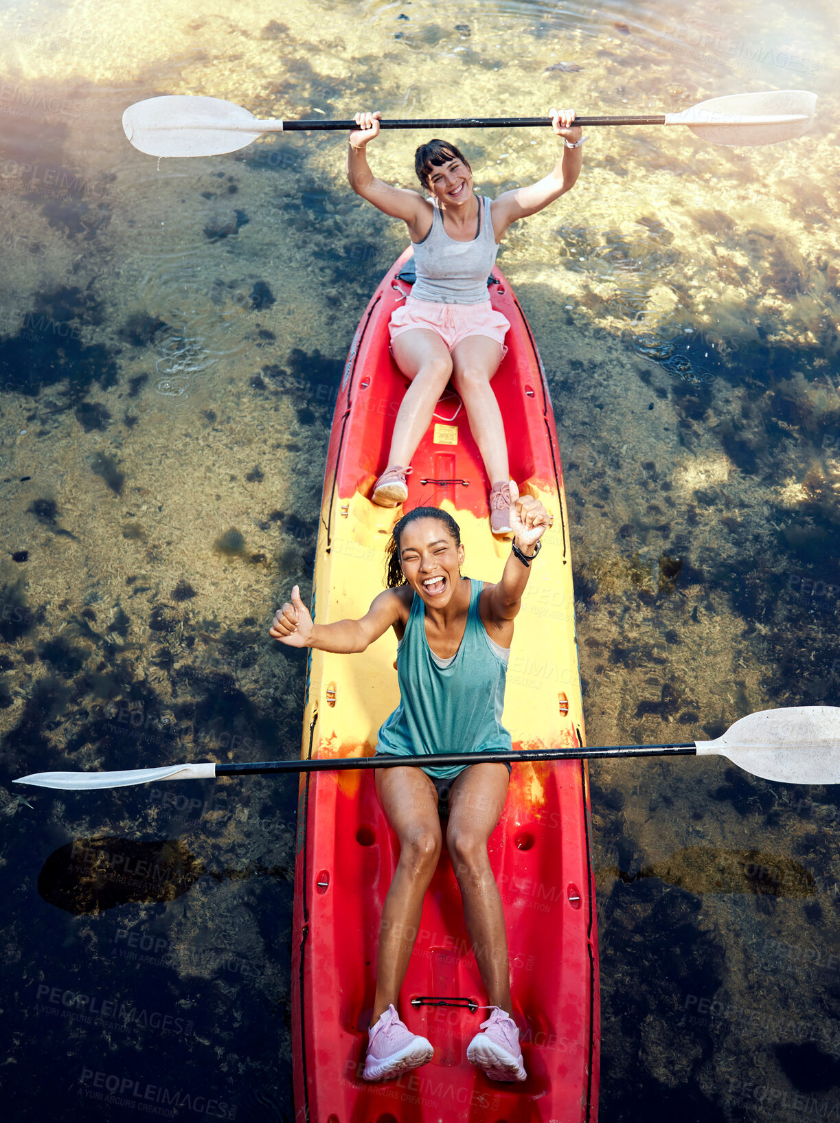 Buy stock photo Above portrait of two diverse young women cheering and celebrating while canoeing on a lake. Excited friends enjoying rowing and kayaking on a river while on holiday or vacation on a weekend getaway