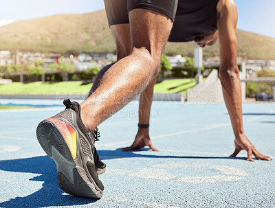 Buy stock photo Close up of an athlete getting ready to run track and field with his feet on starting blocks ready to start sprinting. Close up of a man in starting position for running a race on a sports track