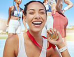 Closeup portrait of mixed race athletic woman showing gold medal from competing in sports event. Smiling fit active latino athlete feeling proud after winning running race. Track runner achieving goal