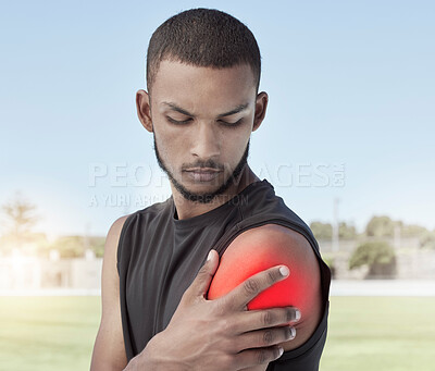 Buy stock photo Closeup of an athlete with shoulder pain after a workout. Side profile of a young sportsman standing on a field holding his stiff and inflamed joint. Muscle strain highlighted in red due to injury
