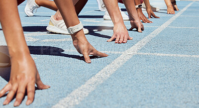 Closeup of determined group of athletes in starting position line to begin sprint or run race on sports track stadium. Hands of diverse sportspeople ready to compete in track and field olympic event