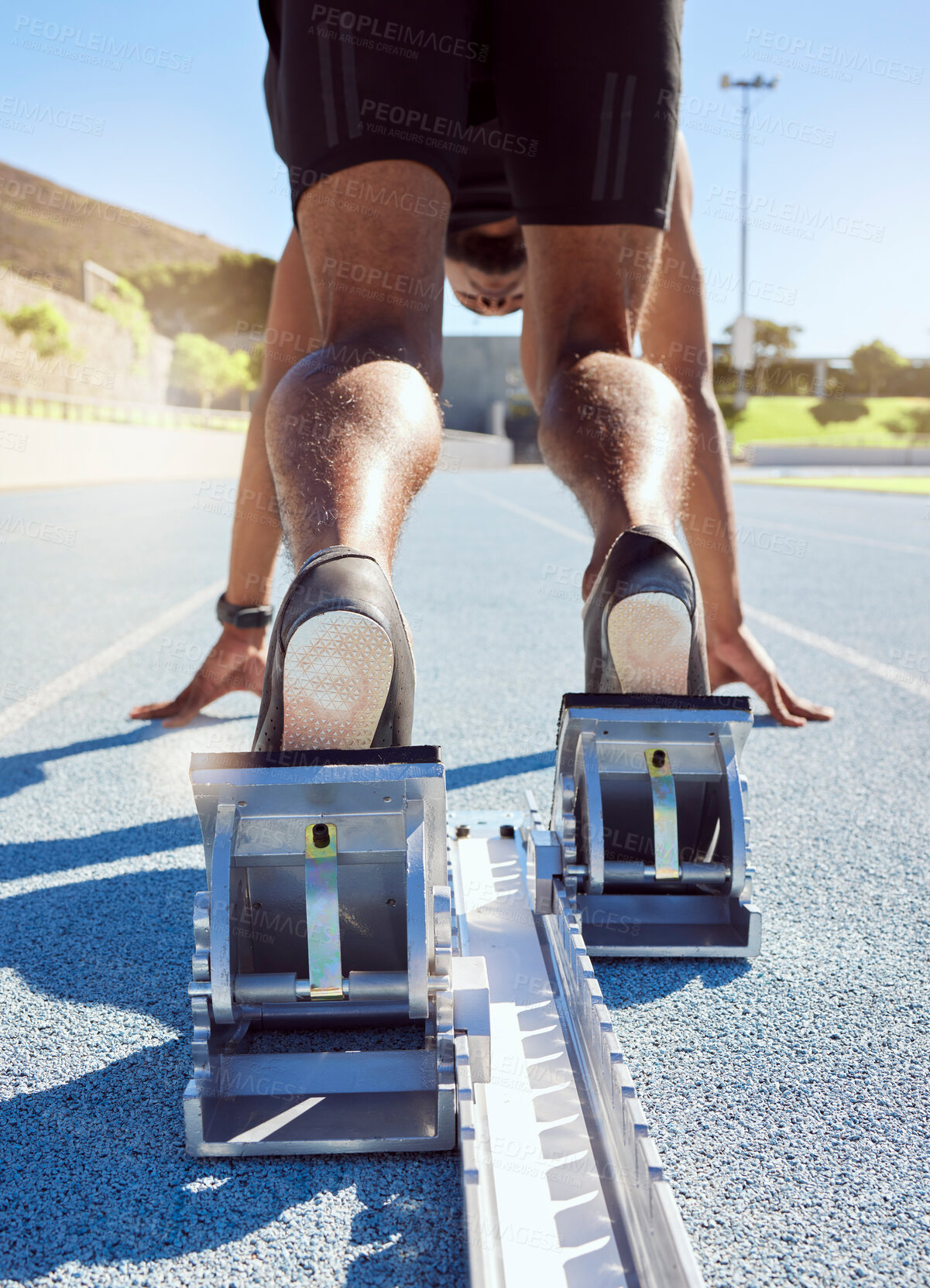 Buy stock photo Feet of athlete in starting position on a running track. A male track and field runner ready to leave the starting block to start his sprint. Sportsman with hands on the starting line during a race