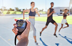 Closeup of hand timing runners on a race track. Blurred athletes racing towards finish line and breaking the record. Stopwatch measuring time for a marathon at a sports event. 