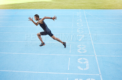 Buy stock photo Athlete running on track during competitive training practice. Full length athletic, fit, active male runner sprinting with speed in sports centre. Exercising cardio health and stamina in workout