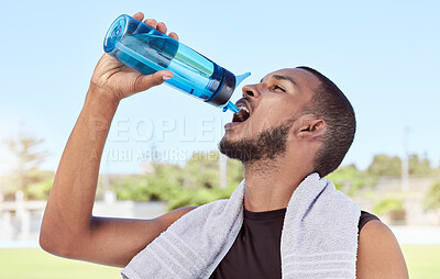 Buy stock photo Fit, active, sporty man taking a break from practice to hydrate and refresh. Hydrating during healthy exercise. Athlete drinking and pouring water from a bottle into his mouth after workout training.