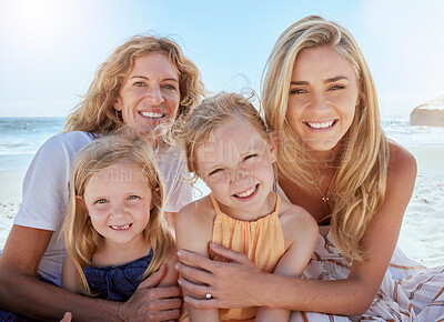 Buy stock photo Portrait of loving and caring mothers bonding and enjoying a day at beach with their little daughters. Girls sitting on the beach with their mom and grandmother while on holiday. Family at the sea