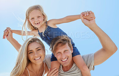 Buy stock photo Portrait of a happy family having fun together with copyspace. Young smiling parents enjoying quality time with their little daughter, relaxing and being playful while on a summer beach vacation 