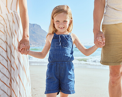 Buy stock photo Portrait of little cute daughter holding her mother and fathers hand while having fun on the beach. A cute smiling little girl standing with her parents on vacation. Fun family summer vacation