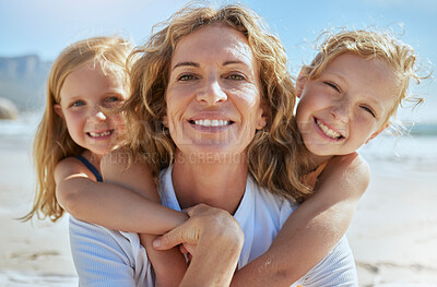 Buy stock photo Portrait of a cheerful mature woman and little girls enjoying family time at the beach on vacation. Happy sisters smiling with adopted mother, grandma or foster parent, enjoying fresh summer air