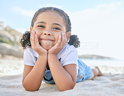 Buy stock photo Portrait of one adorable little playful girl relaxing with her hands on her face on a mat at the beach shore. Cheerful cute innocent latino girl smiling while having fun on a summer vacation