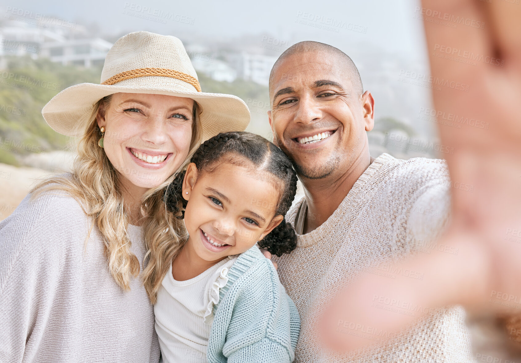 Buy stock photo Cheerful father taking a selfie with his wife and daughter in nature. Parents taking a photo with their daughter. Little girl with her parents. Young carefree family spending a day outside together. 