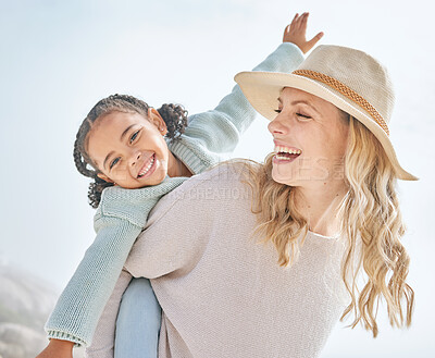 Buy stock photo Portrait of a mother and daughter having fun and bonding on a beach vacation together. Happy adopted black child being playful and cute with her caucasian foster mom. Parent and kid enjoying summer 
