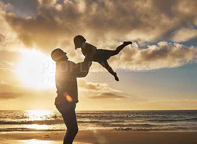 Buy stock photo Silhouette of a loving father holding up his little child on the beach. Parent spending time with their daughter while on holiday. Happy little girl playing and bonding with her dad on vacation