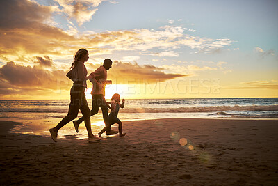 Buy stock photo Silhouette of a carefree family running and having fun together during sunset on the beach. Parents spend time with their daughters on holiday. Little girl playing with her parents while on vacation