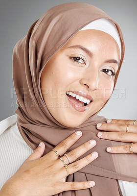 Buy stock photo Studio portrait of beautiful and modest muslim woman isolated against a grey background. Young woman wearing a hijab or headscarf showing traditional arab modesty while smiling and looking at camera