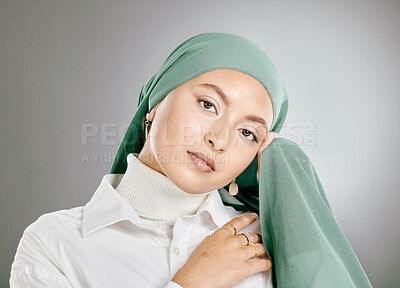 Buy stock photo Studio portrait of beautiful muslim woman isolated against a grey background. Young woman wearing hijab or headscarf showing traditional arab modesty holding her hands together and looking at camera