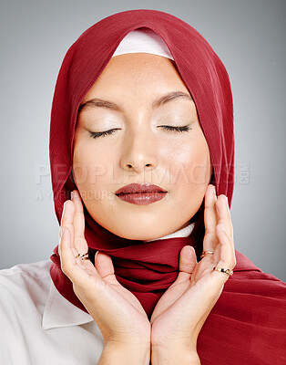 Buy stock photo One beautiful young muslim woman with eyes closed wearing red headscarf and lipstick against grey studio background. Modest arab female wearing makeup with face covered in traditional hijab
