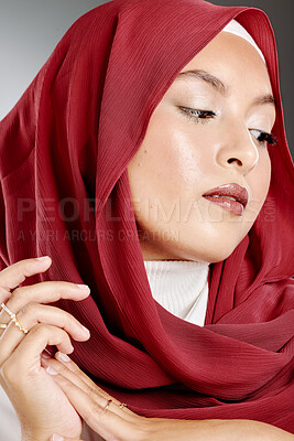 Buy stock photo Elegant muslim woman posing in a studio wearing a hijab. Headshot of a gorgeous and confident arab model standing against a grey background. Fashionable woman wearing a headscarf