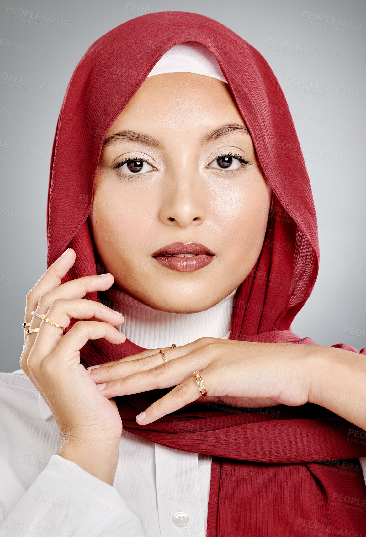 Buy stock photo Closeup portrait of a stylish muslim woman posing in a studio with a hijab. Headshot of a stunning confident arab model isolated against a grey background. Zoomed in on fashionable middle eastern