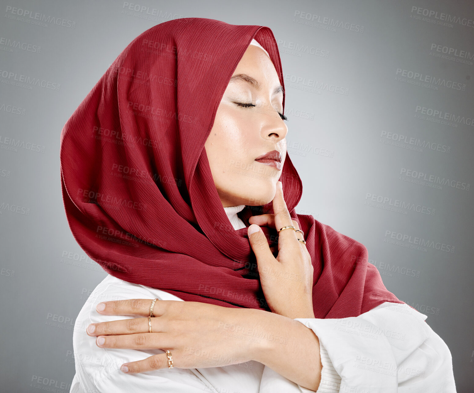 Buy stock photo Beautiful muslim woman posing in studio wearing hijab. Headshot of stunning confident arab model standing against grey background. Fashionable woman wearing a headscarf. Elegant female in a headwrap