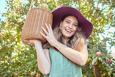 Buy stock photo Portrait of apple farmer harvesting fresh fruit on farm. Happy young woman using a basket to pick and harvest ripe apples on her sustainable orchard. Surrounded by green plants, growth or agriculture