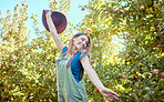 One excited energetic happy young woman jumping for joy on sustainable apple orchard farm on sunny day. Cheerful farmer feeling optimistic and fulfilled for harvest season of fresh organic fruit